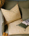 Housse de coussin Tulipan à motifs Curcuma sur un canapé vert