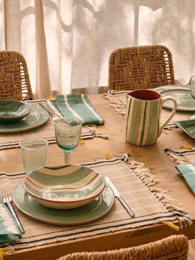 Table d'été dressée avec la vaisselle Amalfi à rayures bleues et blanches en terre cuite