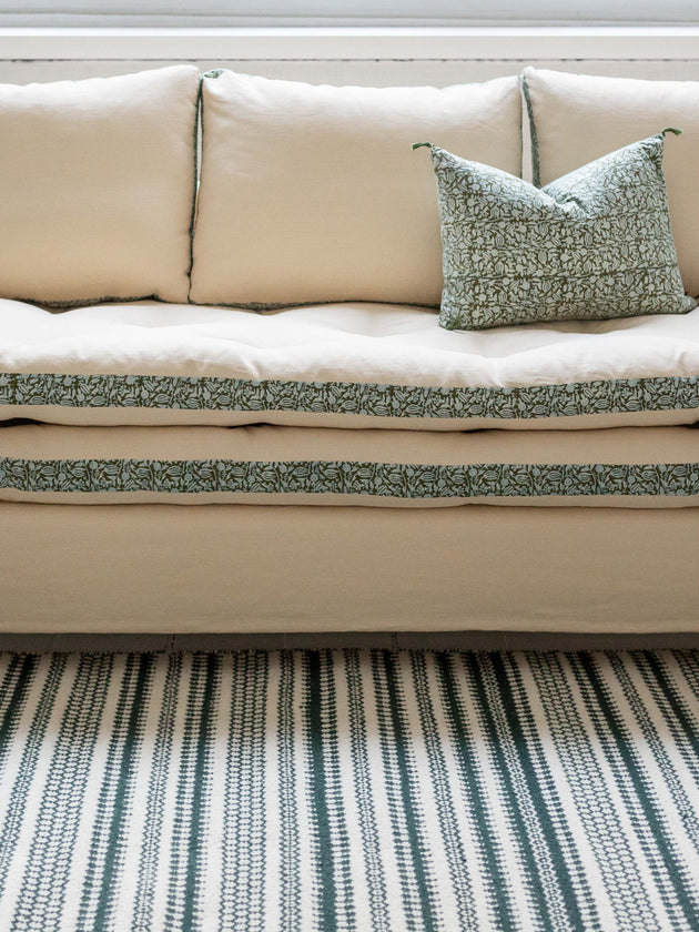 Canapé blanc avec des imprimés végétaux verts autour des coussins