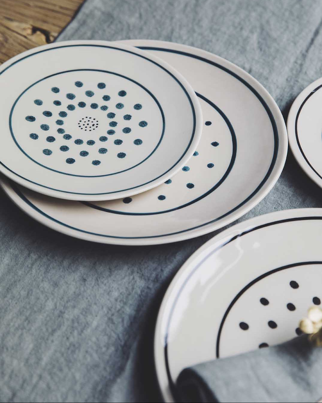 Assiettes originales blanches avec des pois noirs