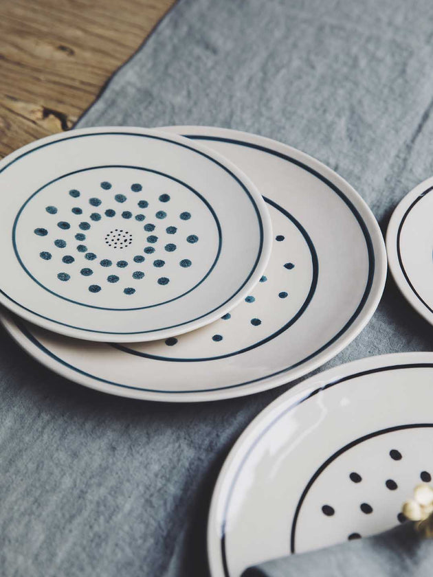 Assiettes originales blanches avec des pois noirs