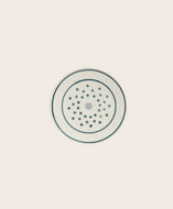 Petite assiette blanche avec des pois bleus