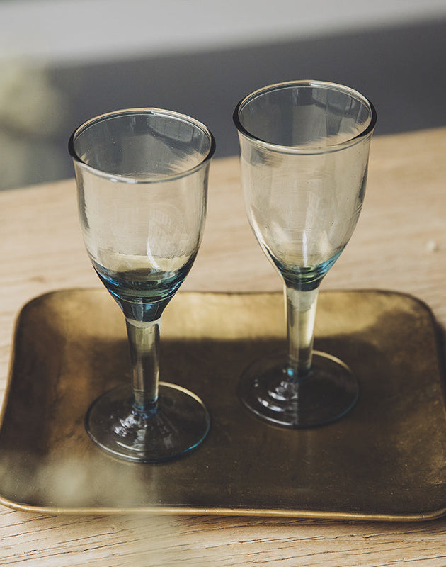 Deux verres à pied Hera en verre recylé sur un plateau doré