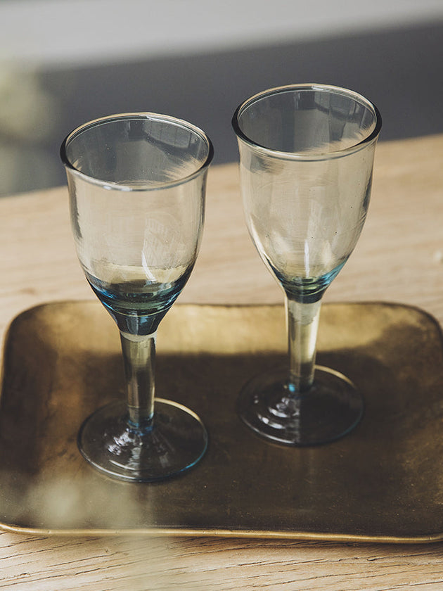 Deux verres à pied Hera en verre recylé sur un plateau doré