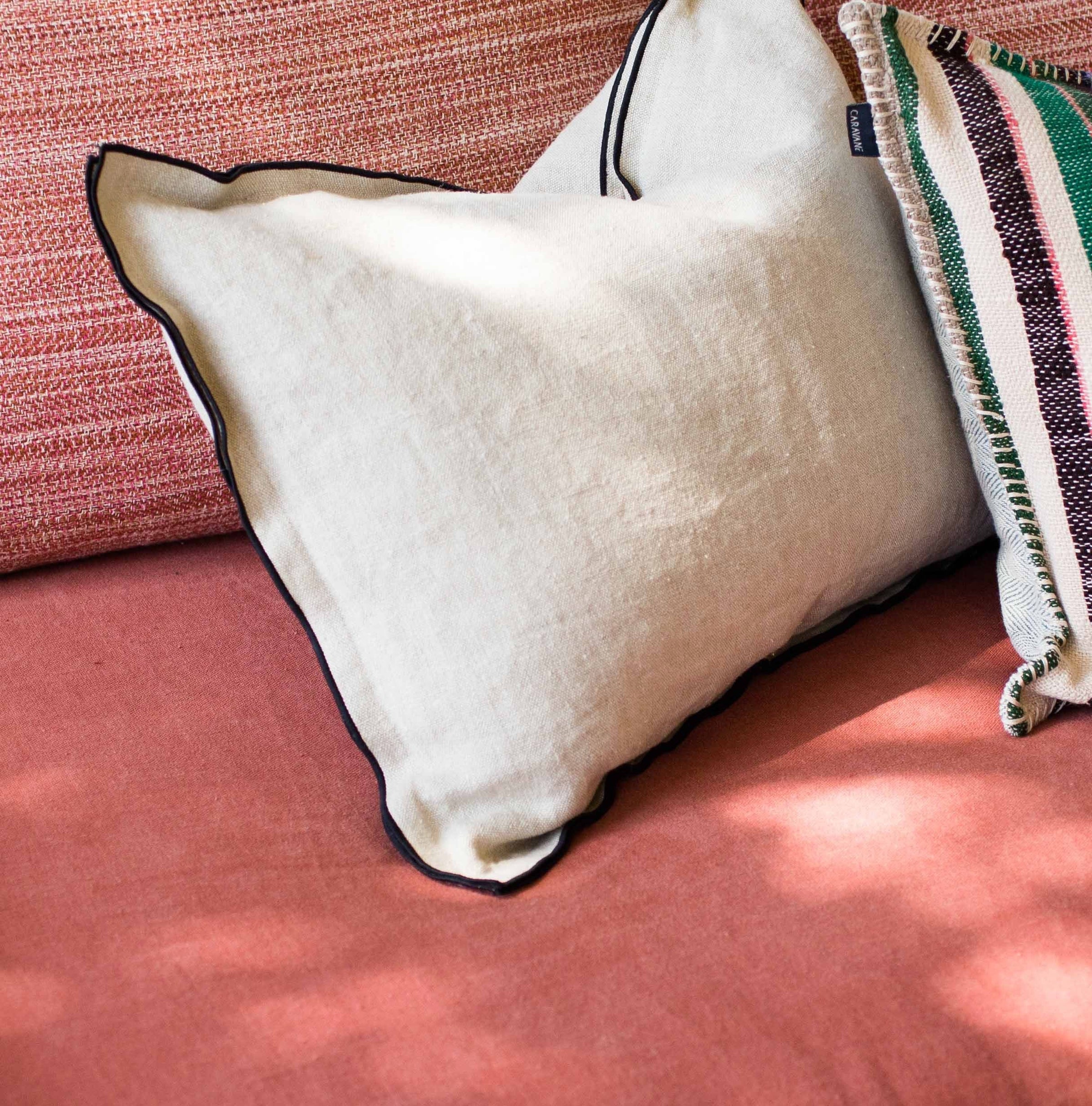 Housse de coussin Maya unie Bise ton blancs et creme avec bourdon noir au pourtour