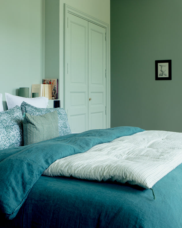 Chambre bleue avec du linge de lit Selena en lin lavé et une courtepointe en bout de lit