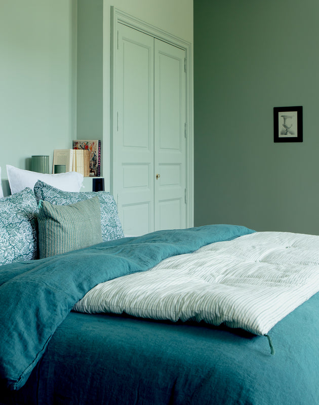 Chambre bleue avec du linge de lit Selena en lin lavé et une courtepointe en bout de lit