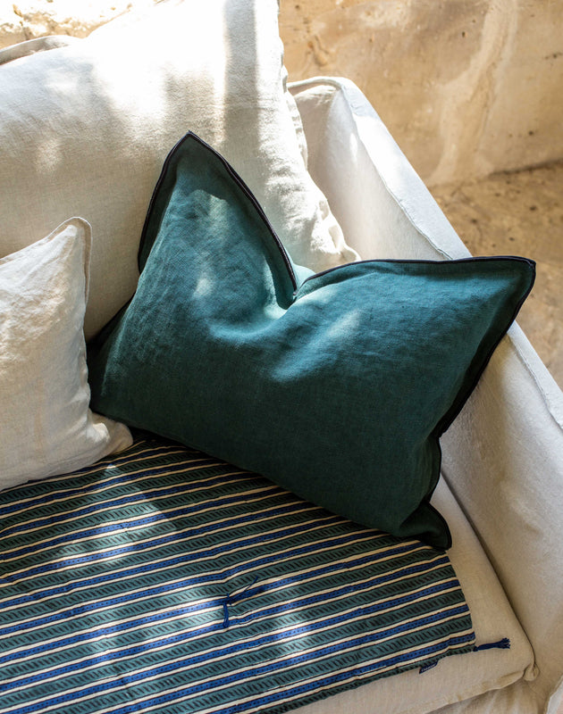 Housse de coussin Maya colvert sur un canapé blanc