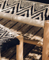 Banc blanc et noir ou bout de lit tressé en coton et bois d'eucalyptus