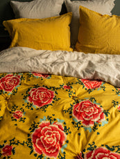 Linge de lit jaune avec des fleurs rouges