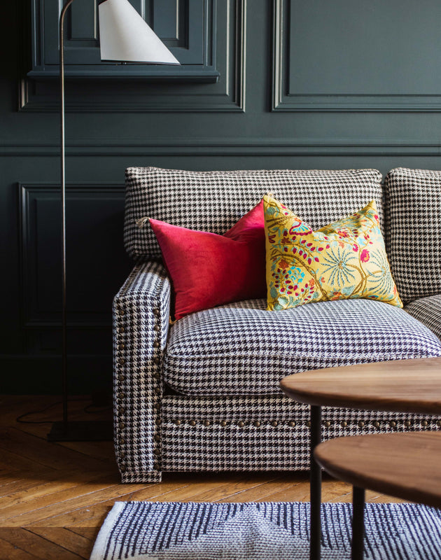 Pied de lampadaire en acier brut et son abat-jour en papier blanc dans un salon chaleureux
