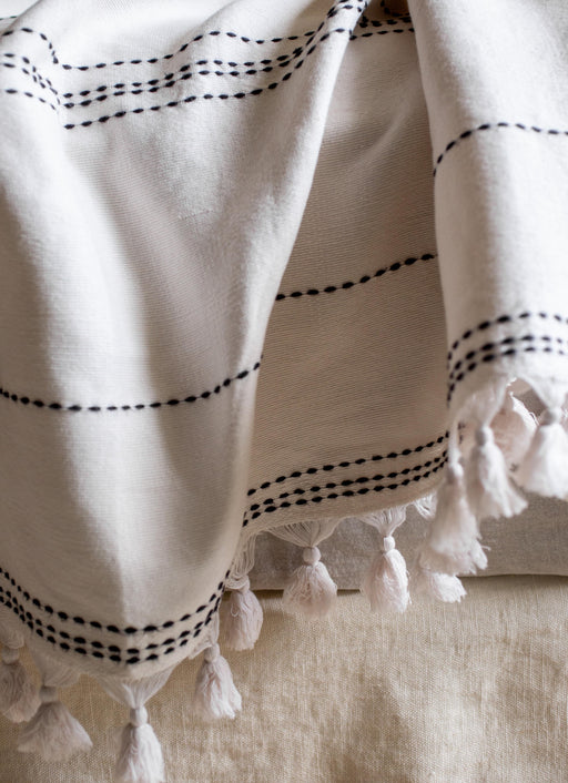 Couvre-lit blanc avec des pompons