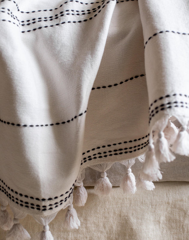 Couvre-lit blanc avec des pompons