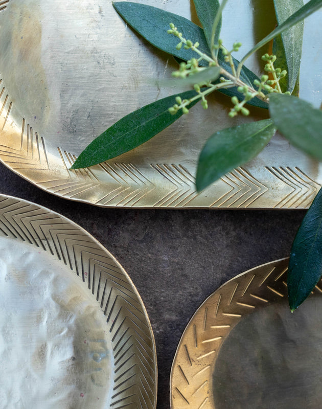 Détail du martellement décoratif des plateaux Dana en laiton doré