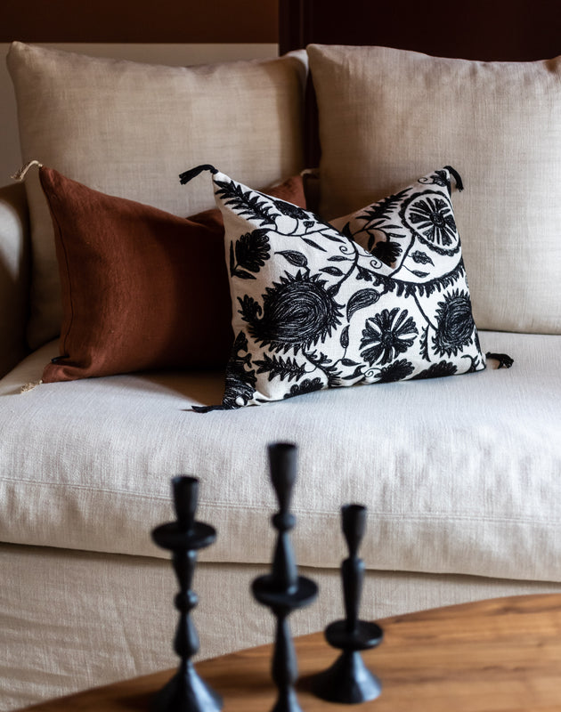 Salon avec un canapé et deux coussins, un en lin Luni et un en coton brodé Anor
