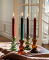 Quatre chandelles en cire et leurs bougeoirs en verre recyclé