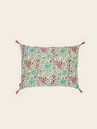 Housse de coussin Papilio turquoise avec son motif floral et ses pompons signatures aux extrémités