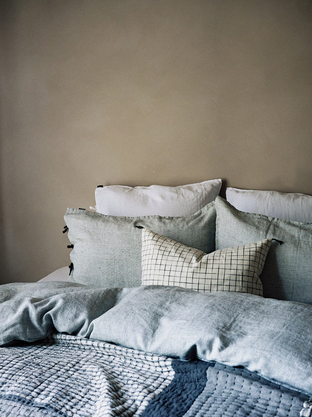 Literie : draps bleus pour un lit à carreaux élégant