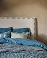 Linge de lit bleu avec une tête de lit blanche
