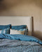 Linge de lit bleu avec une tête de lit blanche