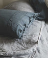 Linge de lit : drap en lin lavé gris avec les taies d'oreiller bleues