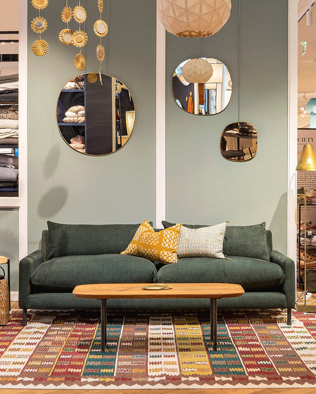 Tapis Tihya dans un salon aux tons verts avec un canapé vert et une table basse en bois