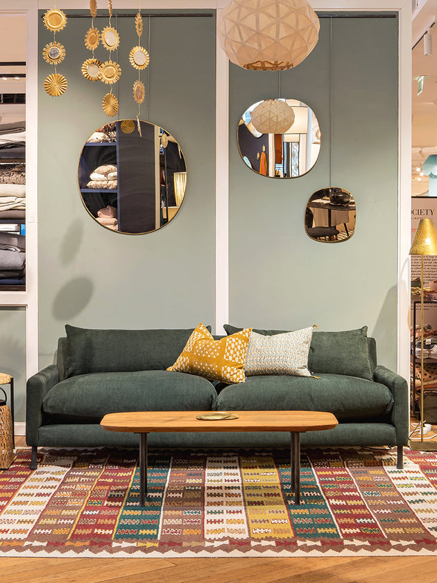 Tapis Tihya dans un salon aux tons verts avec un canapé vert et une table basse en bois