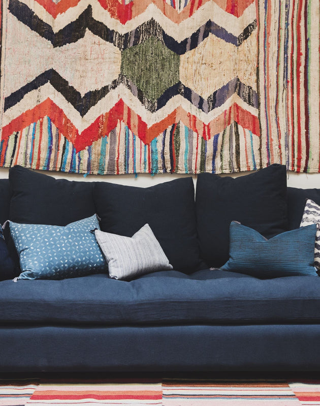 Canapé bleu très confortable grâce à ses nombreux coussins