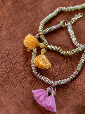 Deux bracelets double pompon en métal et coton rose clair et jaune