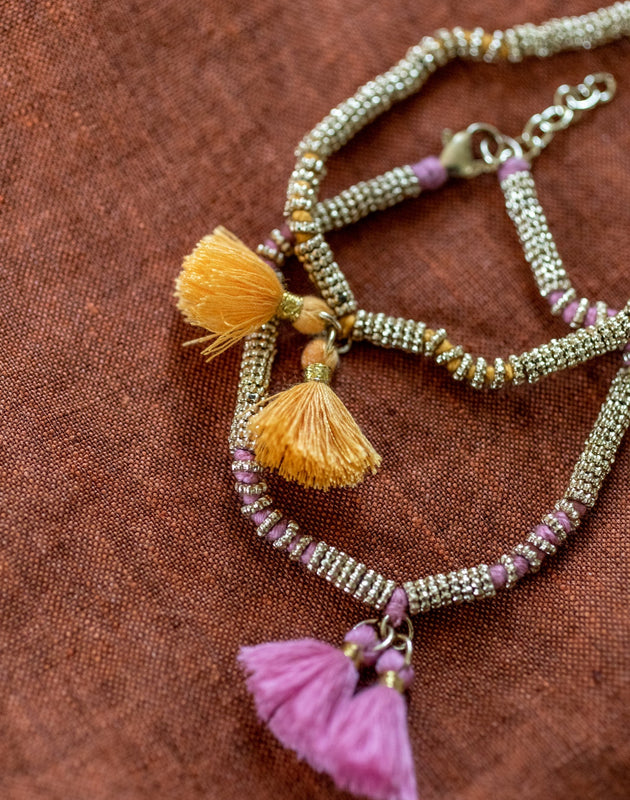 Deux bracelets double pompon en métal et coton rose clair et jaune