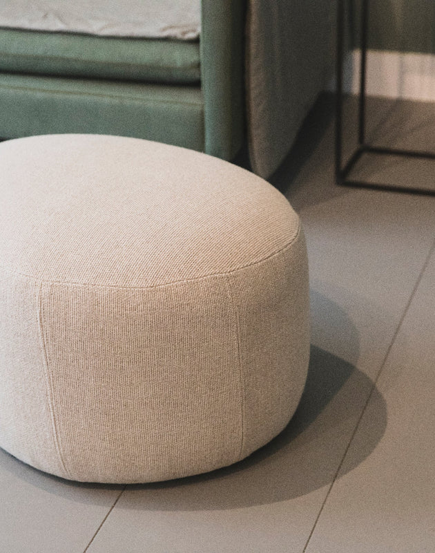 Petit pouf rond en tissu clair pour salon 