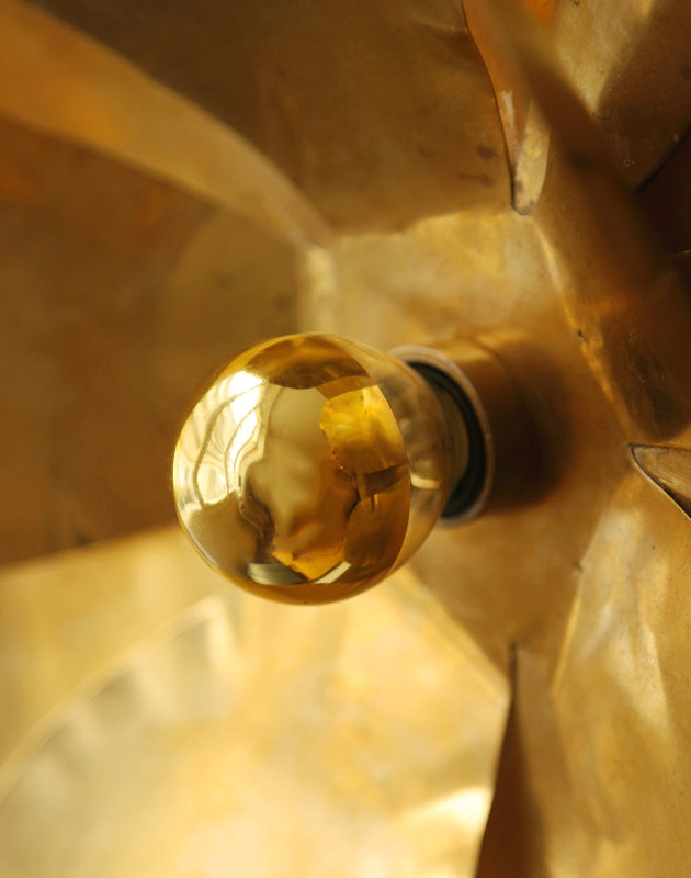 Luminaire doré avec son ampoule dorée qui diffuse une lumière chaude